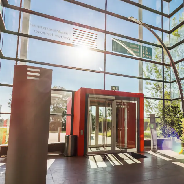 Eingangshalle des Produktionstechnischen Zentrums Hannover (PZH) in Garbsen mit Glasfassade und roter Drehtür